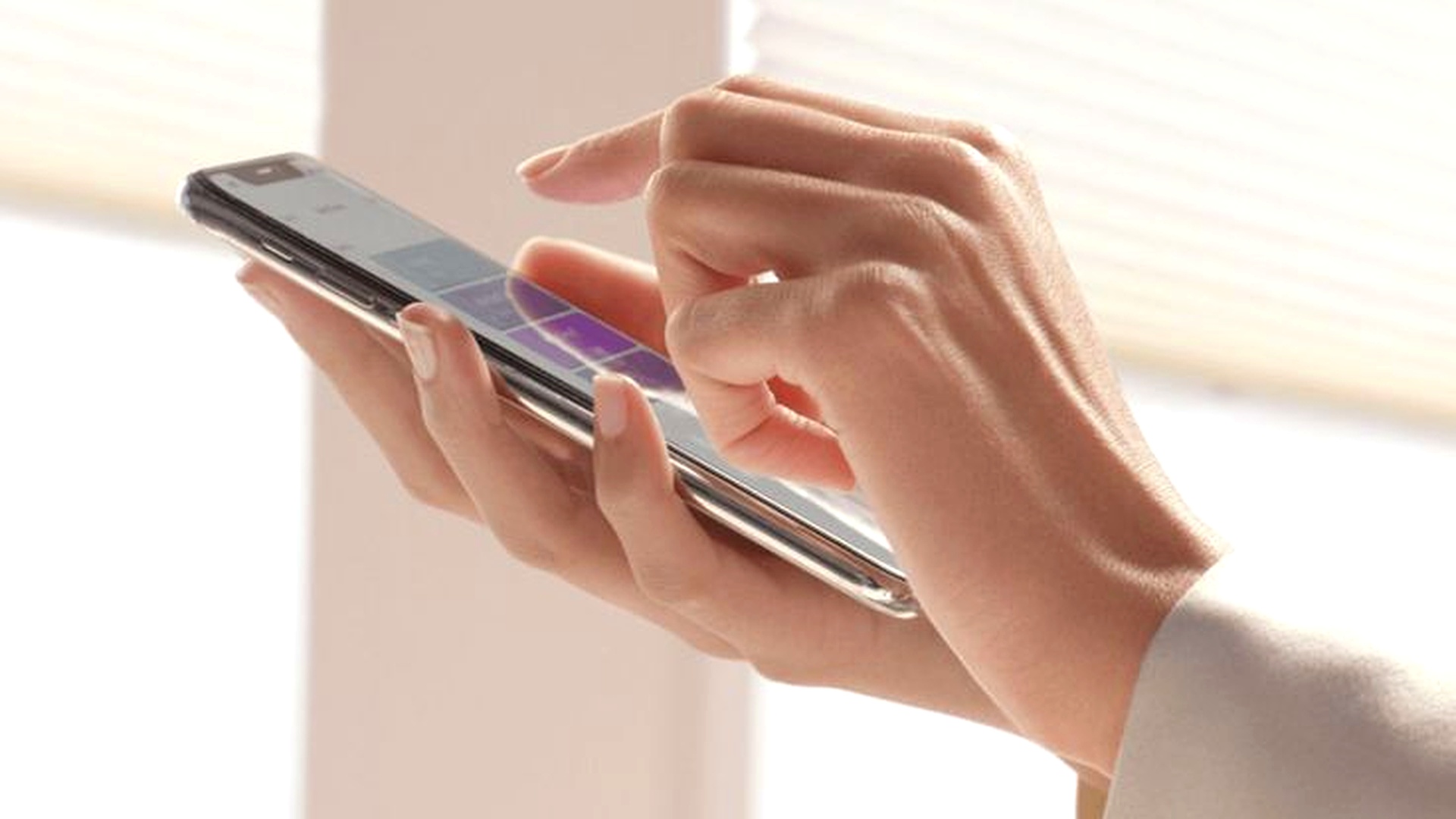 Pessoa controlando persiana motorizada pelo aplicativo no smartphone