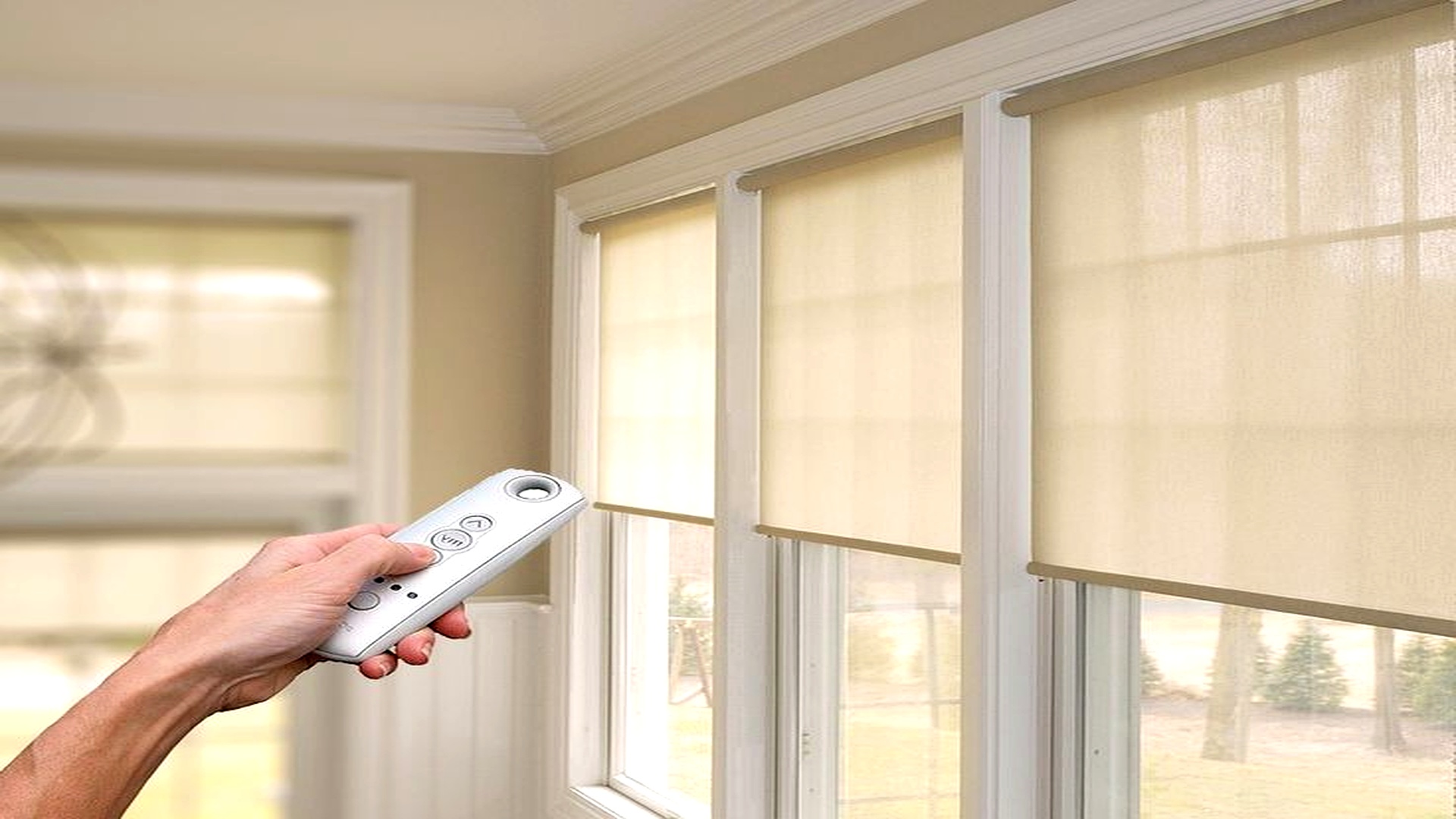 Persiana rolô motorizada sendo controlada por controle remoto em ambiente residencial
